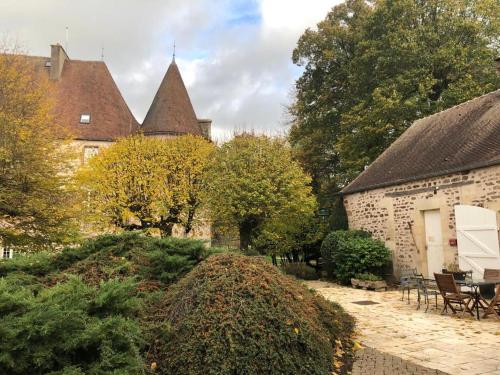 a courtyard of a house with trees and bushes at Domaine familial du château de Ragny in Savigny-en-Terre-Plaine