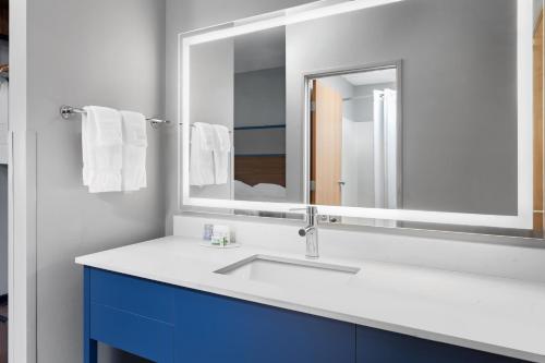 a bathroom with a sink and a mirror at AmericInn by Wyndham Eagle River Downtown in Eagle River