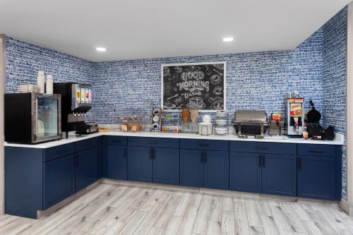 a kitchen with blue cabinets and a chalkboard on the wall at AmericInn by Wyndham Eagle River Downtown in Eagle River
