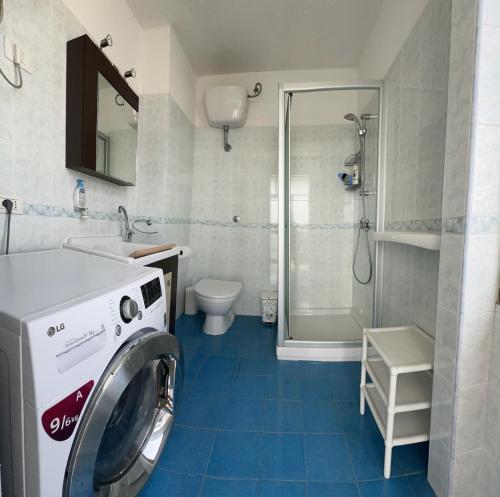 a bathroom with a washing machine and a shower at Poetto Casa Bach Ck in Quartu SantʼElena