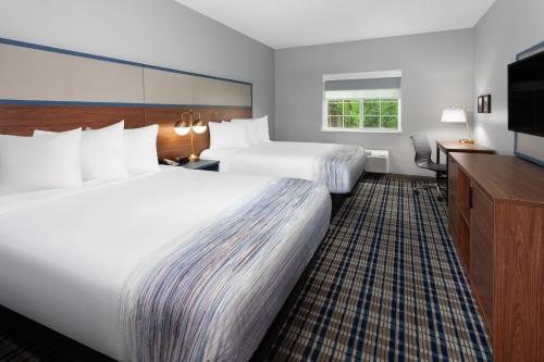 a hotel room with two beds and a flat screen tv at AmericInn by Wyndham Eagle River Downtown in Eagle River