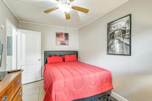 a bedroom with a bed with red sheets and a ceiling fan at 1 Mi to Robins AFB Family-Friendly Home! in Warner Robins
