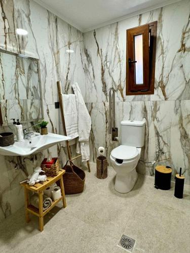 a marble bathroom with a toilet and a sink at Viento Boutique in Skafidia