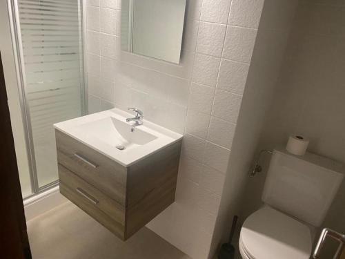 a white bathroom with a sink and a toilet at Auberge de l'Ours in Les Collons