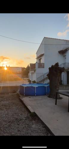 une grande piscine bleue en face d'un bâtiment dans l'établissement Haut de Villa, Jardin, Piscine !, à Fos-sur-Mer