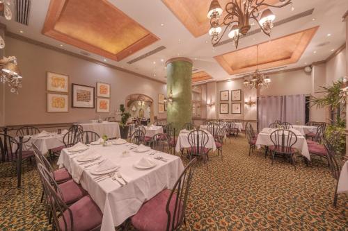 a dining room with tables and chairs and a chandelier at Hotel Santa Anita a Balderrama Hotel Collection in Los Mochis