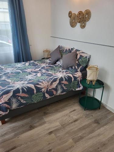 - une chambre avec un lit et une table verte dans l'établissement Calme - Wifi - Netflix - Stationnement gratuit, à Lens