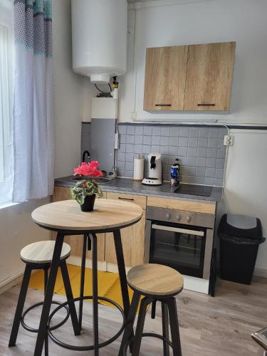 - une petite cuisine avec une table et deux tabourets dans l'établissement Calme - Wifi - Netflix - Stationnement gratuit, à Lens