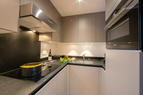 une cuisine avec des armoires blanches et un évier dans l'établissement Chalet du Glacier - Happy Rentals, à Chamonix-Mont-Blanc