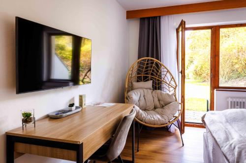 a living room with a desk and a chair at Naturhotel Blaubach in Blaubach