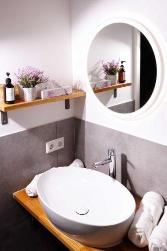 a bathroom with a white sink and a mirror at Naturhotel Blaubach in Blaubach