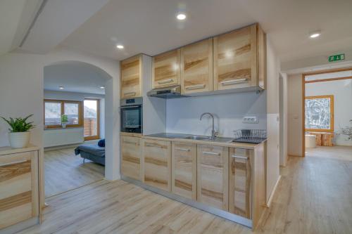a kitchen with wooden cabinets and a sink at Farmhouse Raspberry Pool&Wellness - Happy Rentals in Vransko