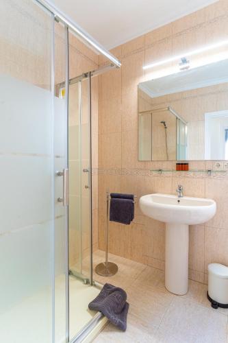 a bathroom with a glass shower and a sink at TrendyHomes City Center in Almería