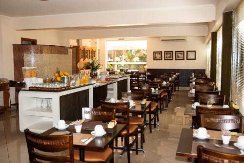 un restaurante con mesas y sillas y un bar en Hotel Premium Pirassununga, en Pirassununga