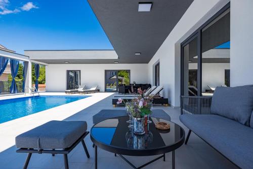 a living room with a couch and a table and a pool at Pool House Fancy - Happy Rentals in Labin