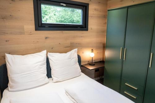 a bedroom with a bed and a window at HofGut Bockelkathen Tiny Haus 10 in Lüdersburg