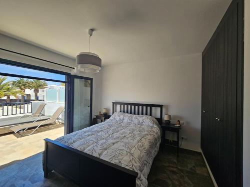 a bedroom with a bed and a balcony with a view at Luna Azul in Playa Blanca