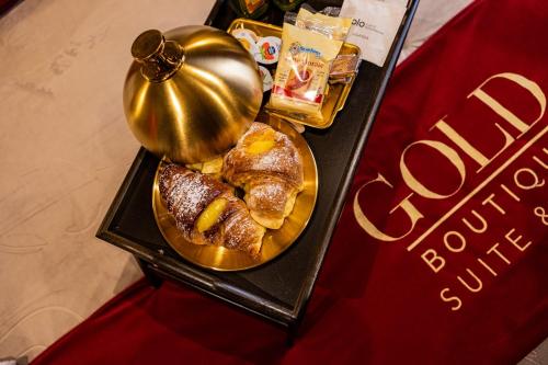 ein Tisch mit einem Teller Gebäck und einer Glocke in der Unterkunft GOLD Suite&SPA in Palermo