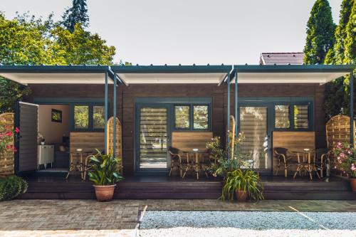 a house with a deck with tables and chairs at Villa Apartman in Makó