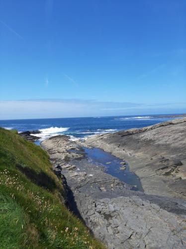 a view of the ocean from the top of a hill at Marys Coastal Retreat in Miltown Malbay