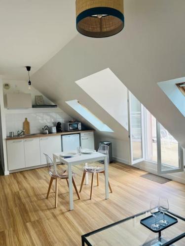 une cuisine avec une table et des chaises dans une pièce dans l'établissement Charmant T2 Landivisiau, à Landivisiau