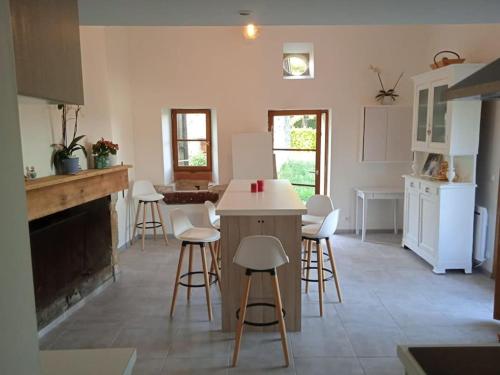 une cuisine avec un comptoir et des tabourets dans une pièce dans l'établissement Chambres chez l'habitant Maison Campagne, à Castelnau-sur-Gupie