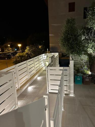 a white fence in front of a building at night at Appartamento Mare in Numana