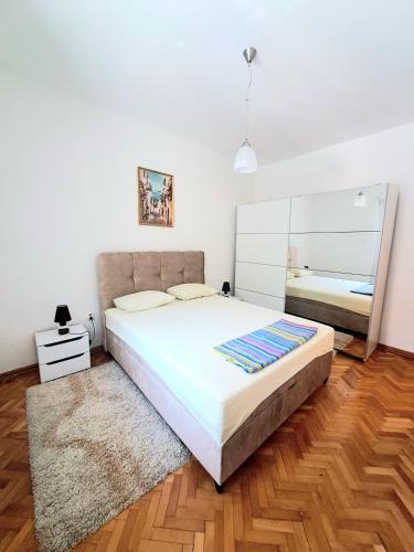 a bedroom with a large bed and a mirror at N&B Apartment Kotor in Kotor