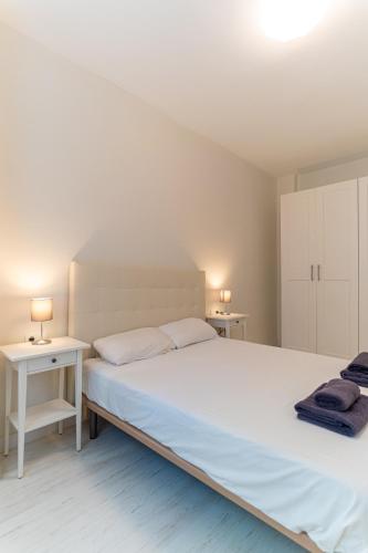 a bedroom with a large white bed and two tables at TrendyHomes City Center in Almería
