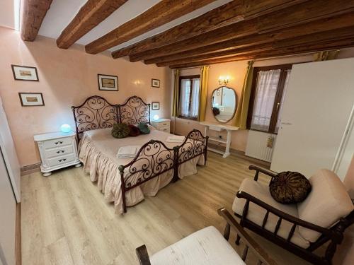 una camera da letto con un letto, una sedia e uno specchio di Ninette Home a Venezia