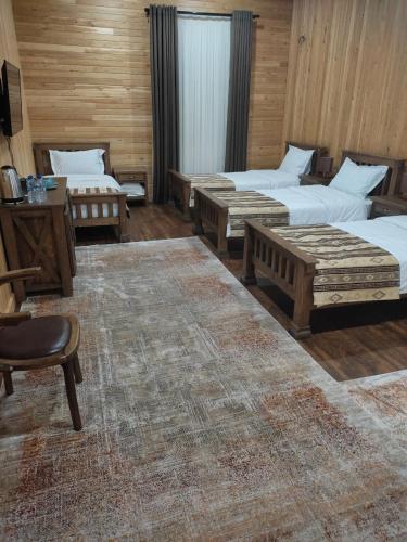 a room with three beds and a table and chairs at LE CHALET MONT And RESTAURANT in Chorwoq