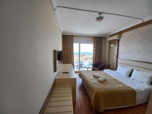 a hotel room with a large bed and a window at Moonstar Hotel in Kusadası