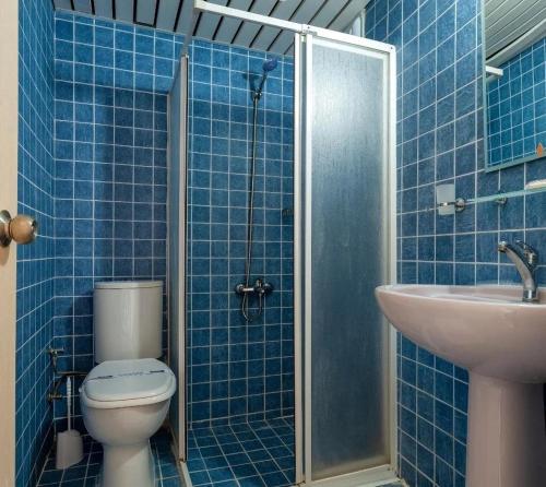 a blue tiled bathroom with a toilet and a sink at Moonstar Hotel in Kusadası