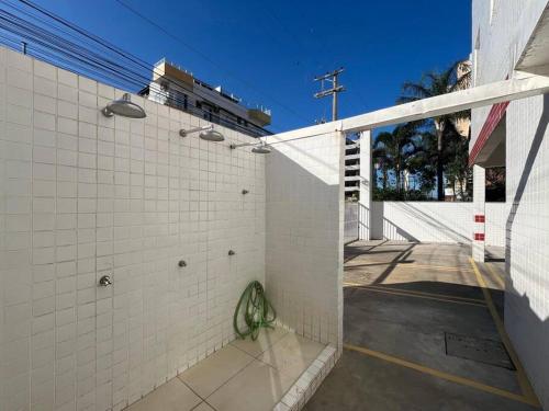 a white tiled wall in a parking lot at Apartamento em Ubatuba! A 100m da praia das Toninhas! in Ubatuba