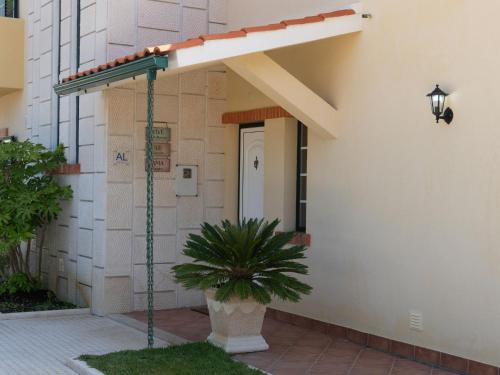 awning on the side of a building with a plant at A Casa Da Praia in Praia de Mira