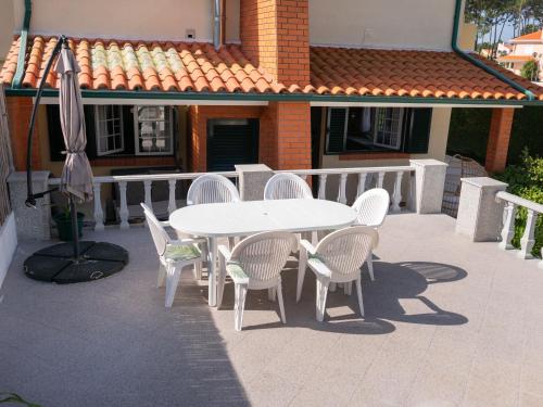 a table and chairs and an umbrella on a patio at A Casa Da Praia in Praia de Mira