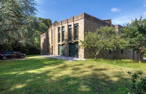 a brick building with a car parked in front of it at AG Casa O Remanso de Pedreira con finca 20000 m in Carballo