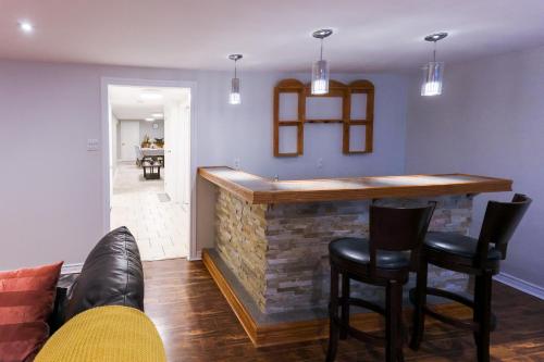 a bar in a living room with black chairs at 1,200sq ft comfy home, perfect location, luxury bedding, feels like home! in Mississauga