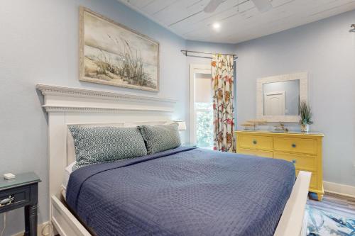 a bedroom with a bed with a blue comforter at The Salty Whale in Galveston