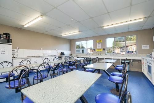 a classroom with tables and chairs in a cafeteria at beach road holiday park in Otatara