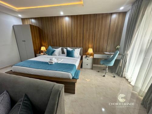 a bedroom with a bed and a desk and a chair at Choice Grande Lagos in Ikeja