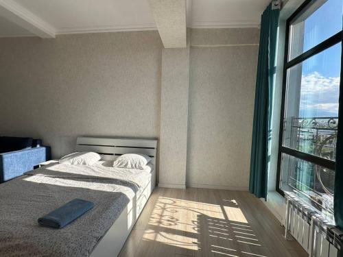 a bedroom with two beds and a large window at Centrum Residence apartment on Turusbekova 9 in Bishkek