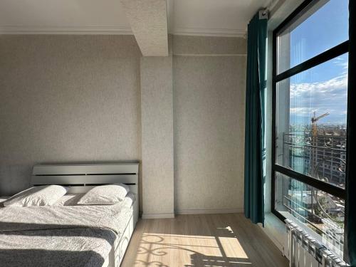 a bedroom with two beds and a large window at Centrum Residence apartment on Turusbekova 9 in Bishkek