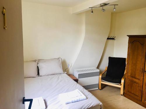 a small bedroom with a bed and a chair at Chambre 1 Namur à vélo in Namur