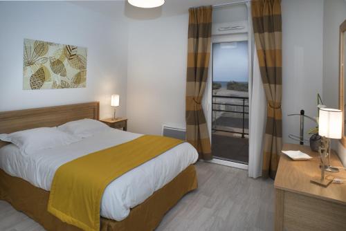 Habitación de hotel con cama y balcón en Domitys Les Dunes D'argent, en Saint-Cyprien