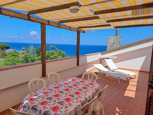 a balcony with a table and chairs and the ocean at Terrazza Michelino in Parghelia