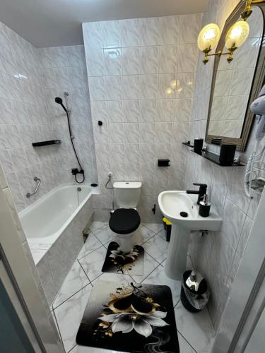 a bathroom with a sink and a toilet and a tub at Butik Hotel w centrum 350m od morza in Ustronie Morskie