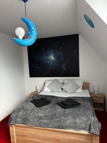 a bedroom with a bed and a painting of the universe at Butik Hotel w centrum 350m od morza in Ustronie Morskie
