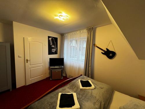 a bedroom with a bed and a guitar on the wall at Butik Hotel w centrum 350m od morza in Ustronie Morskie
