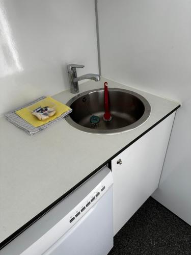 a kitchen counter with a sink and a book at Anneks med udsigt in Helsinge